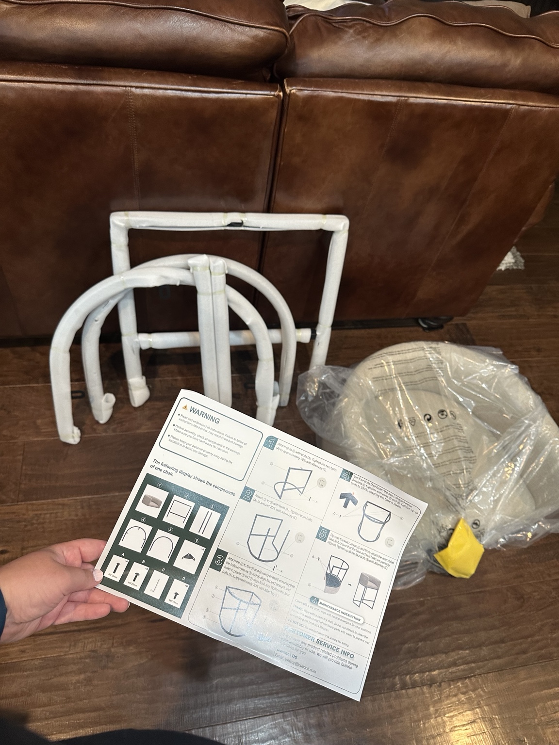 Owner’s original photo of the stool seat, wrapped frame components, and assembly instructions before assembly.